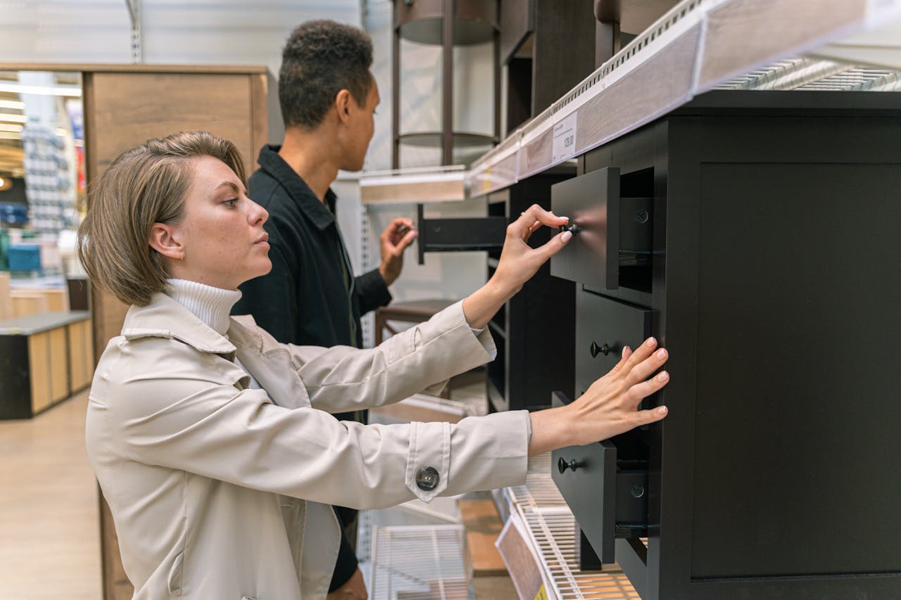 about-01 A man and woman examining drawers in a furniture store, exploring options.